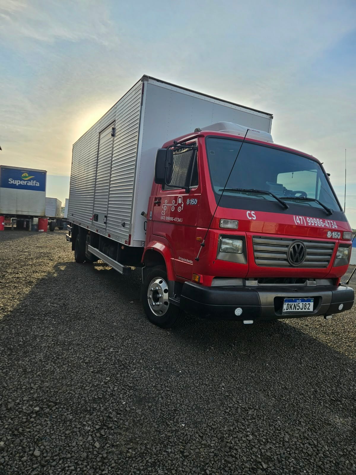 Caminhão baú vermelho da CS Transportadora pronto para carregar ao amanhecer