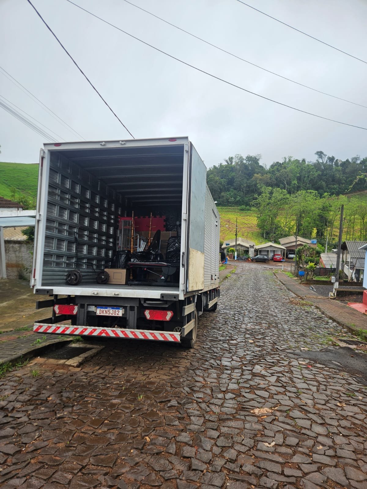 Baú aberto da CS Transportadora carregado com móveis e volumes de uma mudança