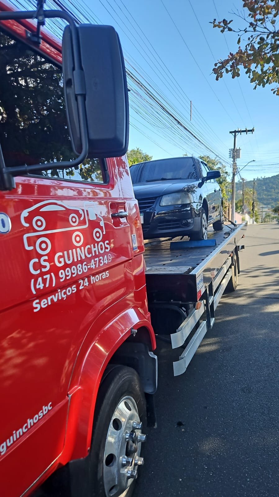 Caminhão plataforma da CS Transportadora transportando um veículo em Santa Catarina